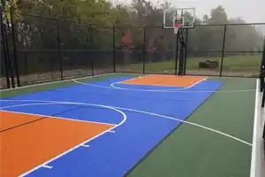 <p>A 30' x 60' SnapSports® multi-game athletic surface featuring a bold blue and orange play zone with green perimeter. This backyard court is set up for basketball, but also supports pickleball and other family-friendly sports thanks to its versatile design.</p>