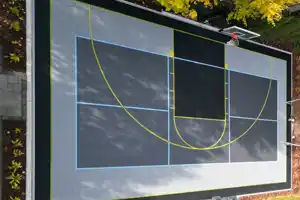 This impressive backyard multi-game court in Ancaster, Ontario, offers a versatile space for diverse sports. Featuring lines for pickleball, a basketball half-court, and a soccer net, it provides a dynamic and engaging environment for active fun at home.