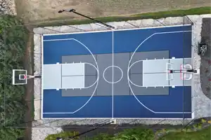 A stunning 40' x 60' modular court in Vanessa, ON, built with SnapSports tiles in bold blue and grey. Ideal for basketball, pickleball, and other sports in a fully enclosed backyard setup.